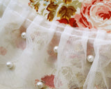 長さの違うスキャロップフリルのチュールレース2枚と、その間にもう一枚のネットレースを重ねた3重のネットレースに、パールが付いた幅のあるフリルレースです。 箱ひだフリルになっているので、曲線にも付けやすいです。 お子様のドレスの襟元の飾りにしたり、コスチュームもパールの落ち着きでシックで華やかになります。